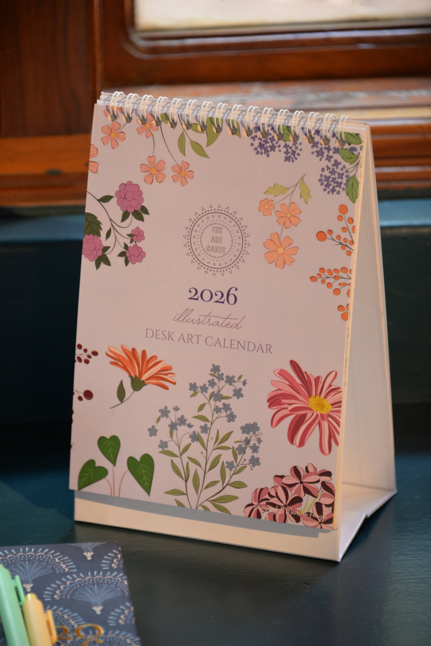 Floral desk calendar for 2026 on a reflective surface