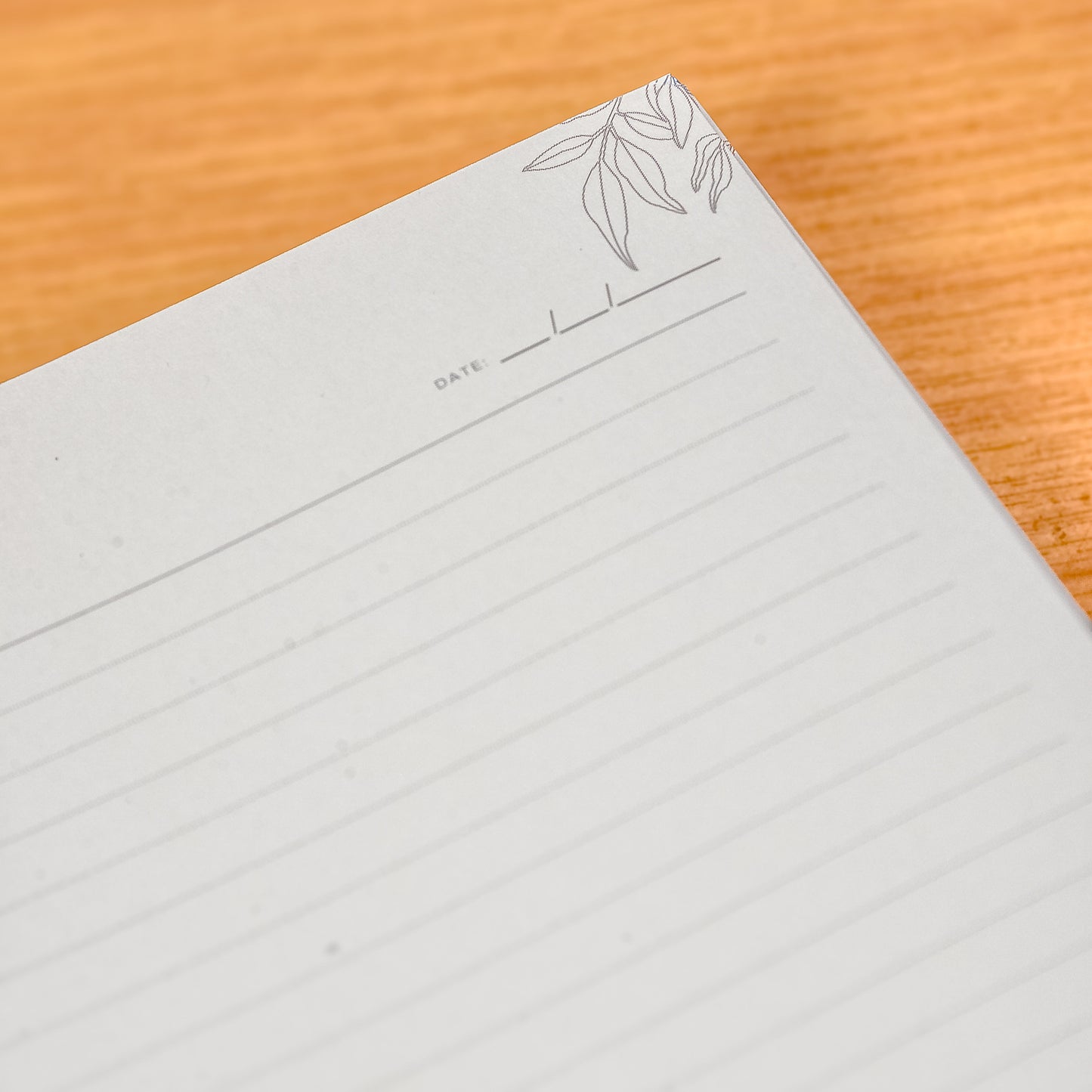 Gray notebook with a decorative corner on a wooden surface