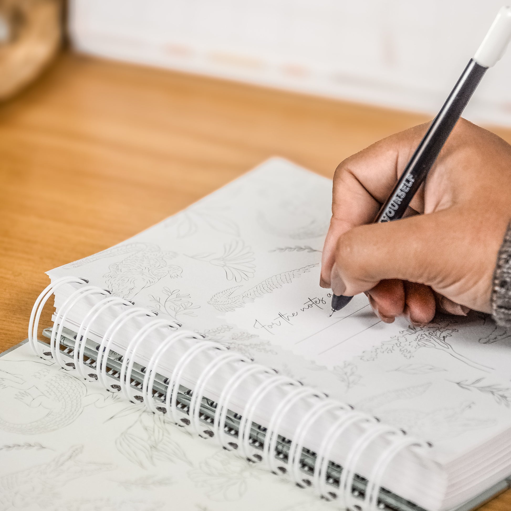 Gray notebook with a decorative corner on a wooden surface